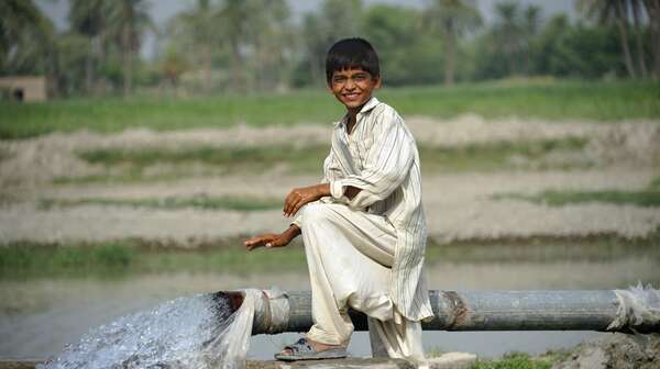 Junge sitzt an Quellfassung