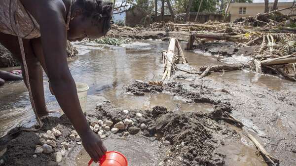 Eine Frau in Haiti schöpft nach Hurrikan Matthew verschmutztes Wasser