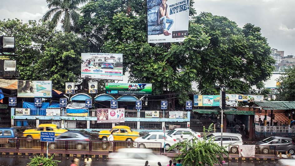 Straße, Autos und das Poster mit dem Spruch "die ultimative Kleidung für Männer"
