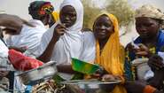 Young women in Niger holding bowls and pots