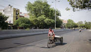 A rickshaw driver on an almost empty street.