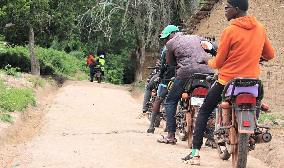 Men on motorcycles at the roadside of a motorcycle track in Liberia