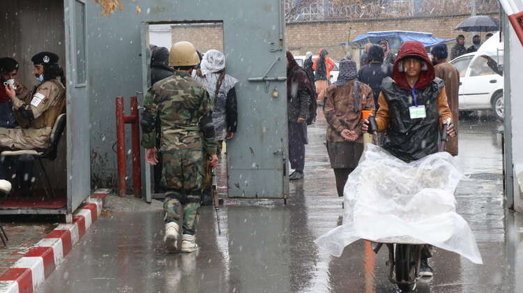 Ein Mann schiebt eine Schubkarre mit Hilfsgütern, Afghanistan 2022.