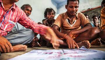 Students are sitting together with a poster in front of them