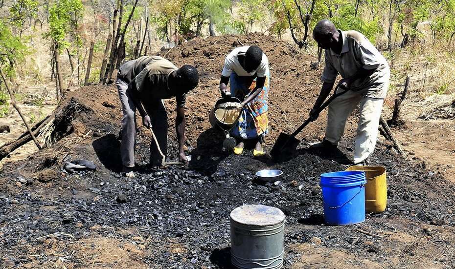 Men working in an illegal charcoal kiln in southern Malawi