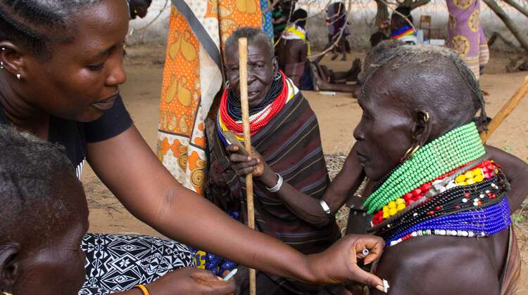 Dürre in Kenia: Eine Frau hält etwas Watte auf den Impfstich eines Mannes.