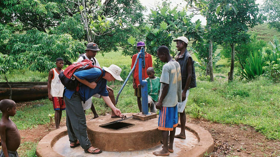 Männer stehen um den Schachtbrunnen