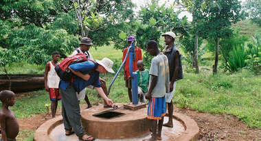 Männer stehen um den Schachtbrunnen