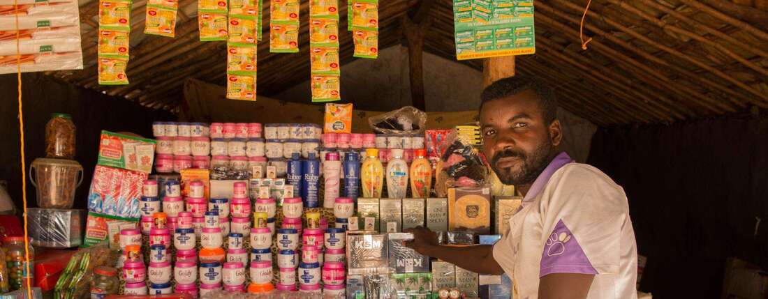 A small trader in front of his store.