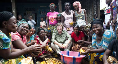 Welthungerhilfe President Marlehn Thieme opening cocoa fruits with a group of women in Sierra Leone.