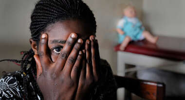 A frightened woman looking through her fingers