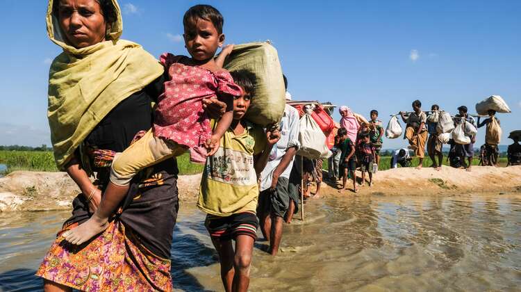 2017-rohingya-auf-der-flucht-fluss-bangladesch_C_Daniel-Pilar-hires.jpg Eine lange Reihe von Frauen, Männern und Kindern waten durch einen Fluss