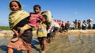 2017-rohingya-auf-der-flucht-fluss-bangladesch_C_Daniel-Pilar-hires.jpg Eine lange Reihe von Frauen, Männern und Kindern waten durch einen Fluss