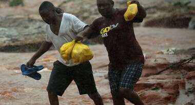 Two men walking through a flooded area