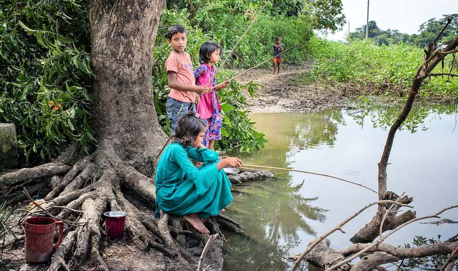 Children gathering at the edge of submerged land