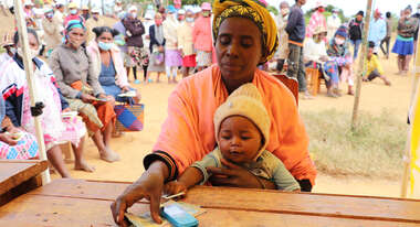 Eine Frau und ihr Baby beim Cash Transfer in Madagaskar.