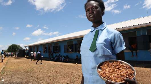 Amok Deng Piol mit ihrer Schulmahlzeit, Aweil, Südsudan 2022