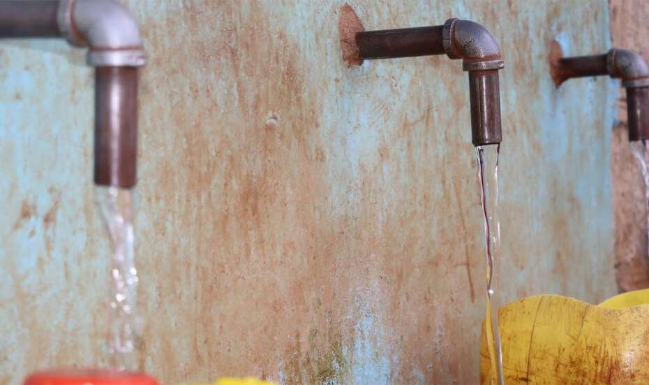 Drinking water flows from several taps into canisters