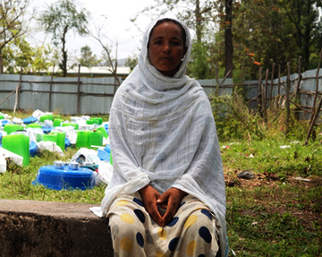 Eine junge Frau sitzt auf einer kleinen Mauer, Äthiopien 2022. 
