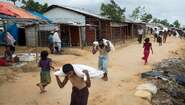 Rohingya refugees are carrying sacks from an aid distribution in camp Hakimpara in Bangladesh, August 2018.
