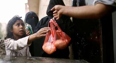 Ein Mädchen bekommt eine Tüte mit Reis.