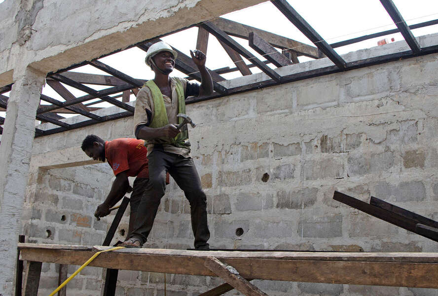 Two men on the scaffolding in the shell of a hospital in Liberia
