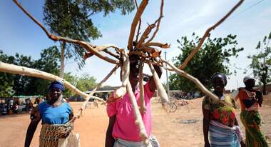 Frauen und Männer transportieren Holz in Dissin, Burkina Faso