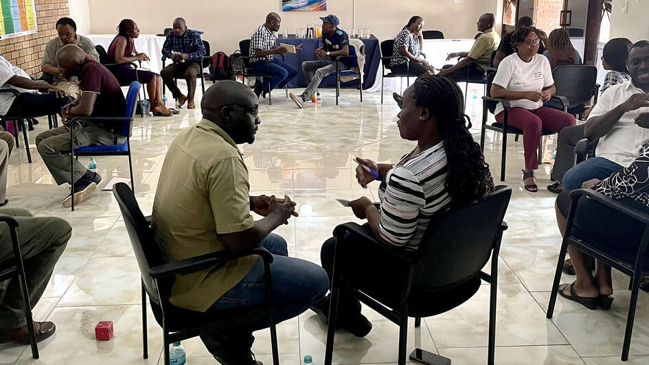Participants exchange ideas during a P-FIM (People First Impact Method) exercise in Bindura, Zimbabwe, in November 2023. P-FIM involves communities in the planning of humanitarian assistance.