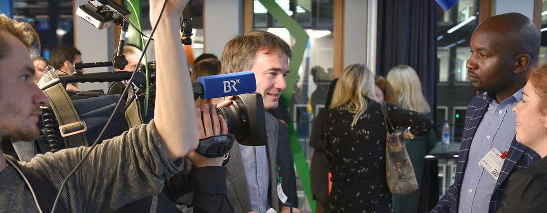 Zwei Welthungerhilfe-Mitarbeiter präsentieren die App "AgriShare"