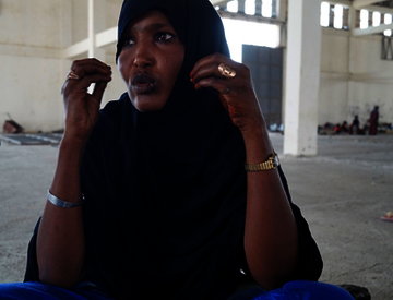 Eine Frau sitzt im auf dem Boden einer großen Halle, Äthiopien 2022.