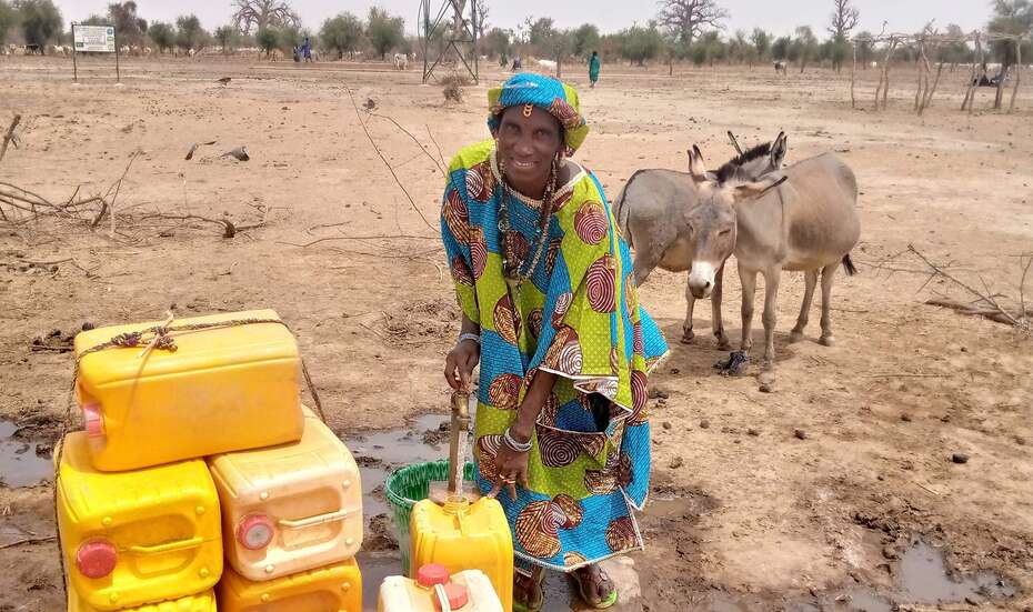 Hawa Sidibé with water cans.