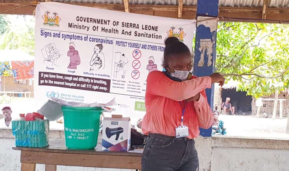 Eine Frau mit Mundschutz demonstriert Schutzmaßnahmen zu Corona.