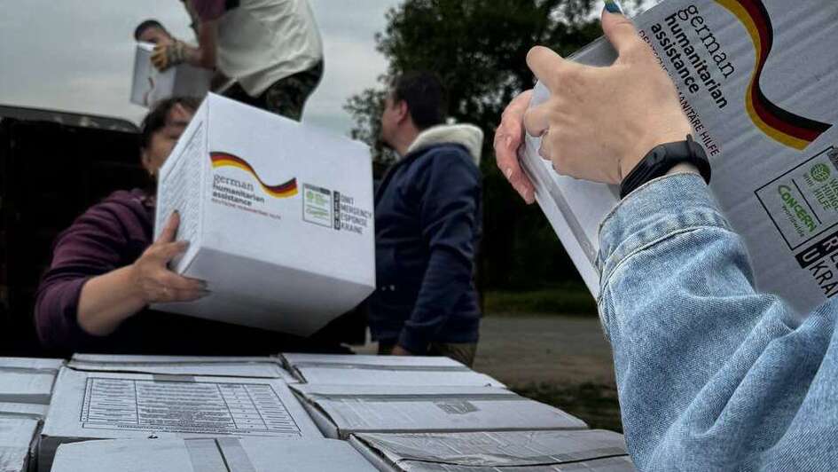 Humanitarian workers in Ukraine carrying packages with hygiene kits