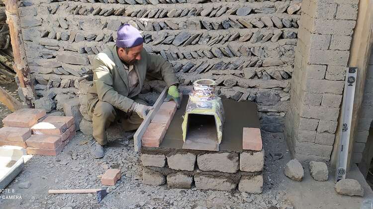 Ein Mann baut einen energieeffizienteren Ofen, Tadschikistan 2021.