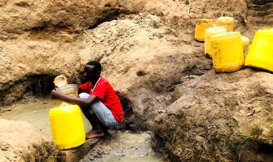 Ein Mann holt Wasser an einer Wasserstelle.