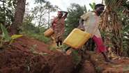 Children crossing an erosion control ditch on their way from the watering hole.