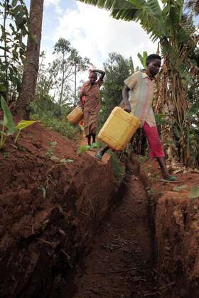 Children crossing an erosion control ditch on their way from the watering hole.