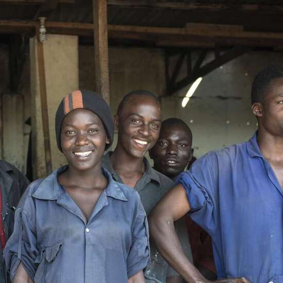 Eine Gruppe Jugendlicher in einer Autowerkstatt