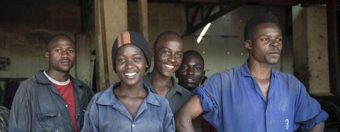 Eine Gruppe Jugendlicher in einer Autowerkstatt