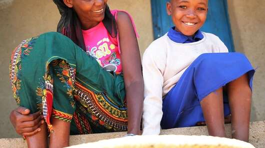 A woman and a girl are sitting on stairs.