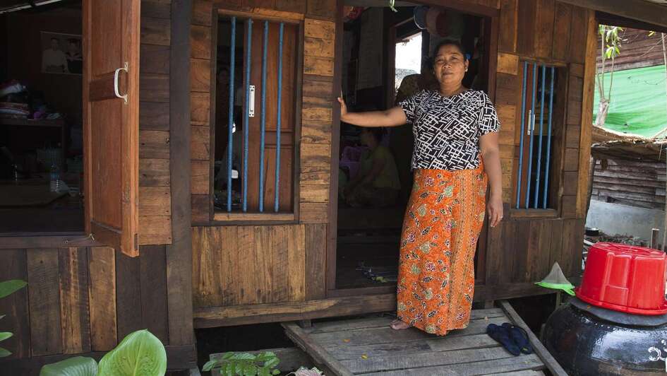 Frau steht vor Hütte