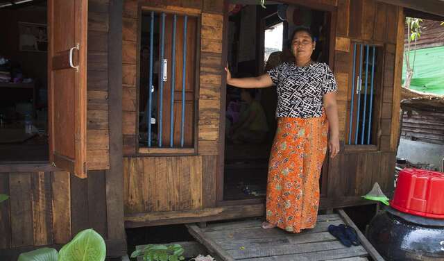 Frau steht vor Hütte