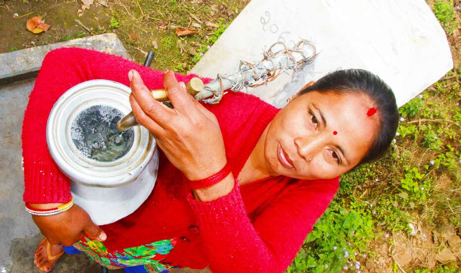 Frau füllt Wasser in einen Krug