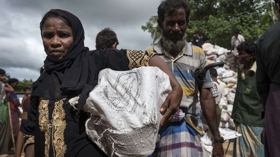 A woman in Hakimpara refugee camp, Bangladesh, with a sack full of fuel.
