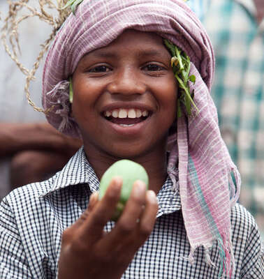 Der achtjährige Jalia Pacharia hält sein Lieblingsessen in die Höhe: einer wilde Gurke. Die Paharia im indischen Dorf Ketokuria sammeln seit jeher Dutzende Sorten wilder Waldgewaechse wie Knollen, Wurzeln, Früchte und Gemüse, doch durch Waldrodungen, finden sie immer weniger Essbares. Der Welthungerhilfe-Partner CWS/Avibyakti Foundation hilft ihnen, die Vielfalt zu erhalten. 