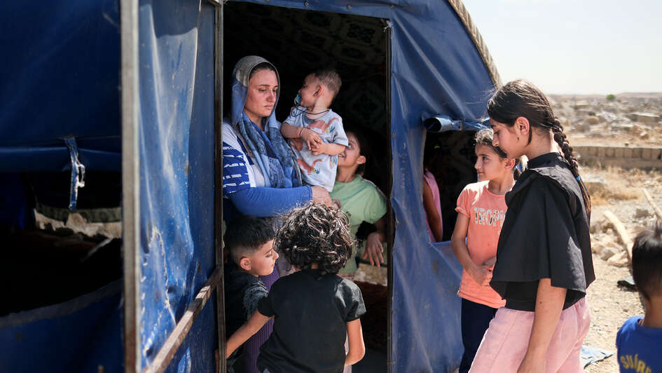 A mother and children stand outside a makeshift accommodation in Sinjar, Iraq.