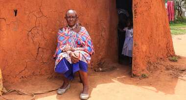 Massai Esther Sululi Makooi in front of cabin.