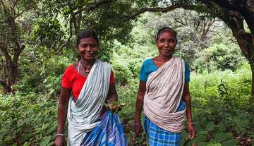Two women walking through the forest