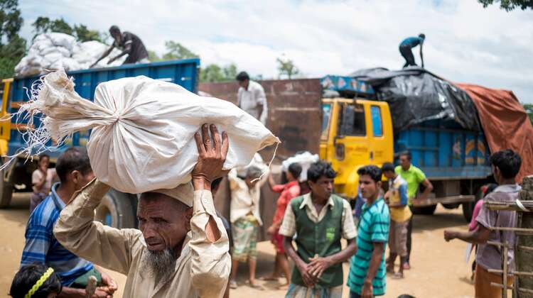 A man is carrying a bag filled with fuel in camp Hakimpara, Bangladesh, August 2018.