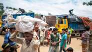 A man is carrying a bag filled with fuel in camp Hakimpara, Bangladesh, August 2018.
